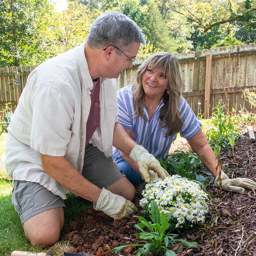 A retired couple plants flowers and feels secure about their financial future, thanks to a fixed annuity from TruStage®.
