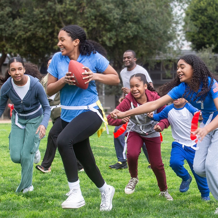 A family plays flag football in their front yard, feeling protected with term life insurance.