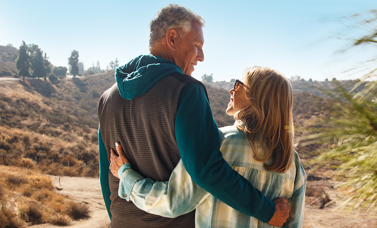 A woman and man on an sunny outdoor hike discuss their retirement which includes ZoneChoice Advantage Annuity from TruStage